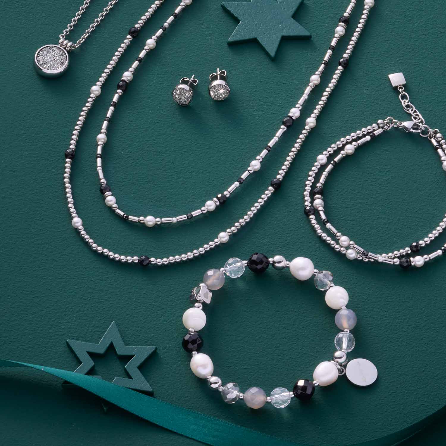 Armband HOPE silber/grau mit Perlen und Schmuckset auf grünem Hintergrund