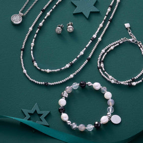 Armband HOPE silber/grau mit Perlen und Schmuckset auf grünem Hintergrund