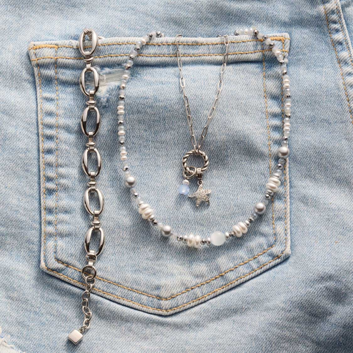Halskette KLARA auf Jeanstasche mit Perlen und Metalldetails
