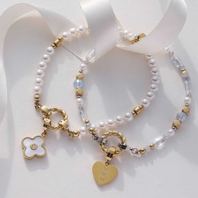 Armband MARIT mit Perlen, Metallplättchen und Anhängern auf weißem Untergrund