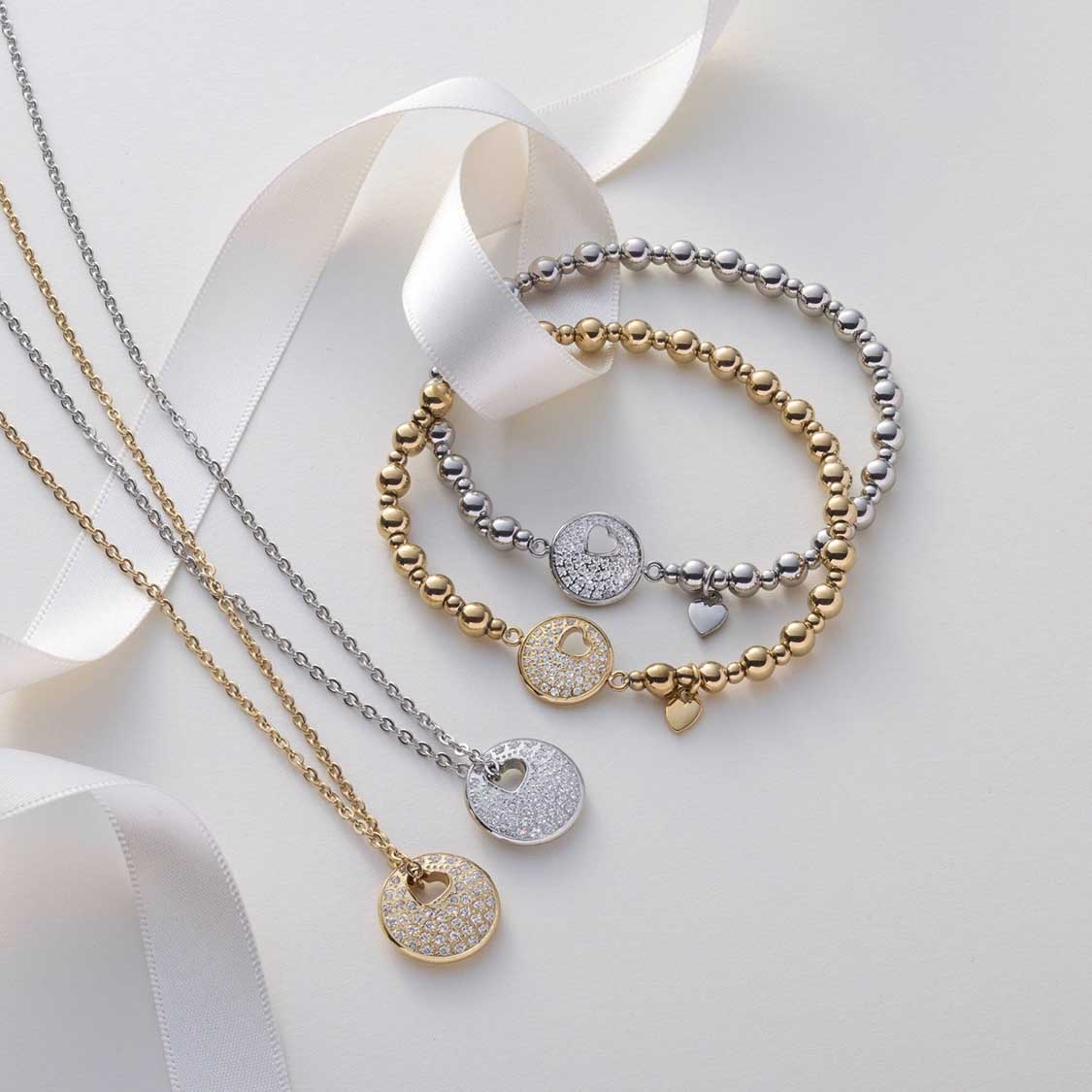 Halskette SUE AMOUR gold mit Kettenanhänger und Armbändern auf weißem Hintergrund