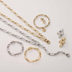 Armband MATHILDE Clip & Mix in Silber und Gold mit Ketten, Verschlüssen und Ohrringen auf Neutralgrau