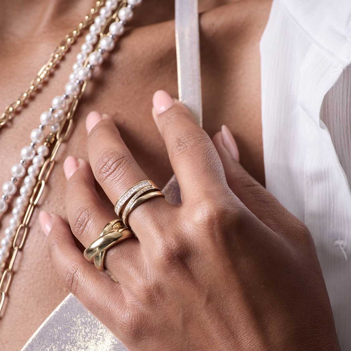Ring LISBETH 17 gold an Hand mit Perlenketten und weißem Textil