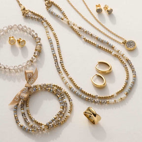 Schmuckkollektion mit Ohrstecker, Ketten, Armbändern und Ringen in Gold und Weiß