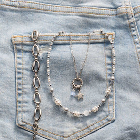 Armband ANDREA mit Perlenkette und Kettenanhänger auf Jeanstasche