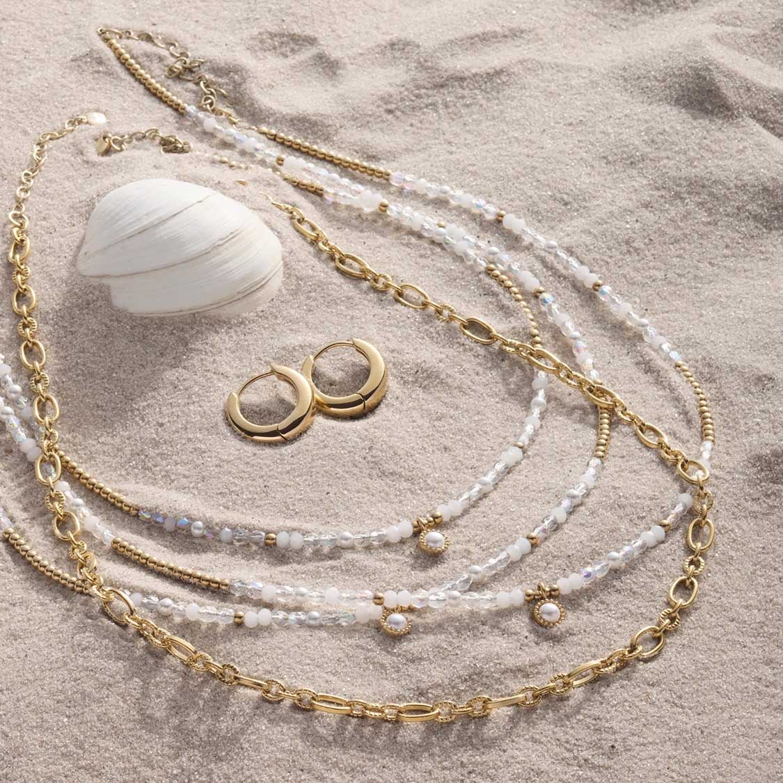 Halskette SOLVANI gold mit Perlen und Ohrringen auf Sand