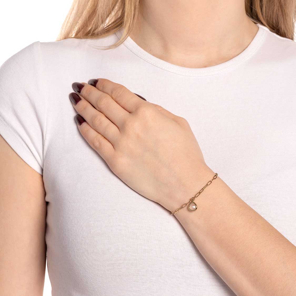 Armband INDRA gold CIAO an Frauenhand getragen, weiß gekleidete Person