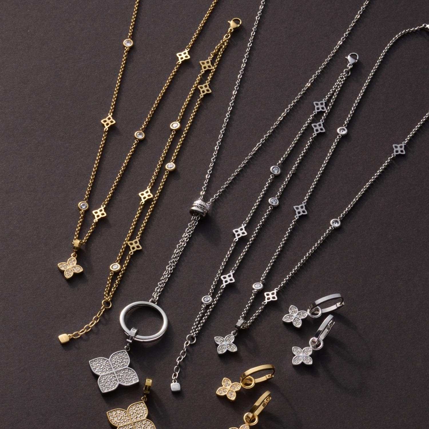 Schmuckkollektionskette mit gold und silberfarbenen Halsketten und Armbändern mit Blütenanhängern