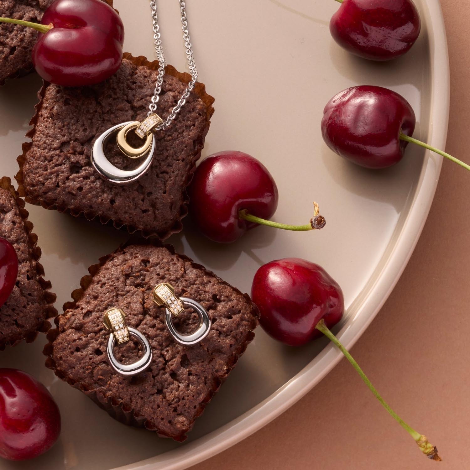 Halskette LIVIA auf Schokoladenkuchen mit roten Kirschen arrangiert