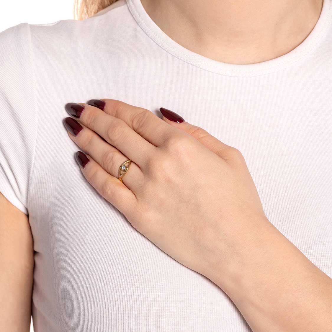 Frau trägt goldenen Ring TAVARI 20 am Finger, dunkle Nägel