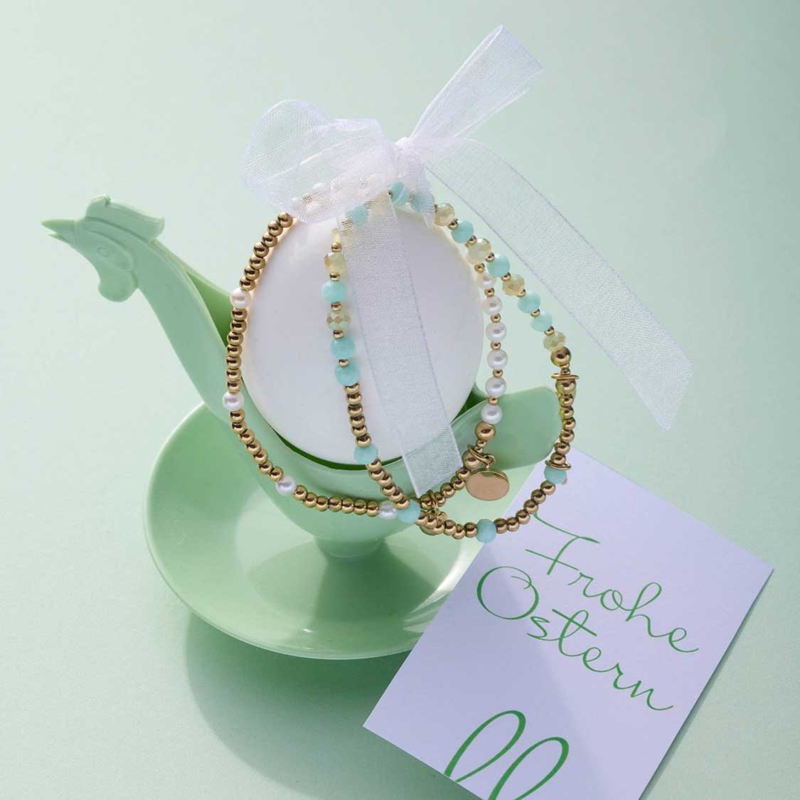 Armband EVELYN gold You & Me CIAO auf grünem Dekoobjekt mit Geschenkband und Grußkarte