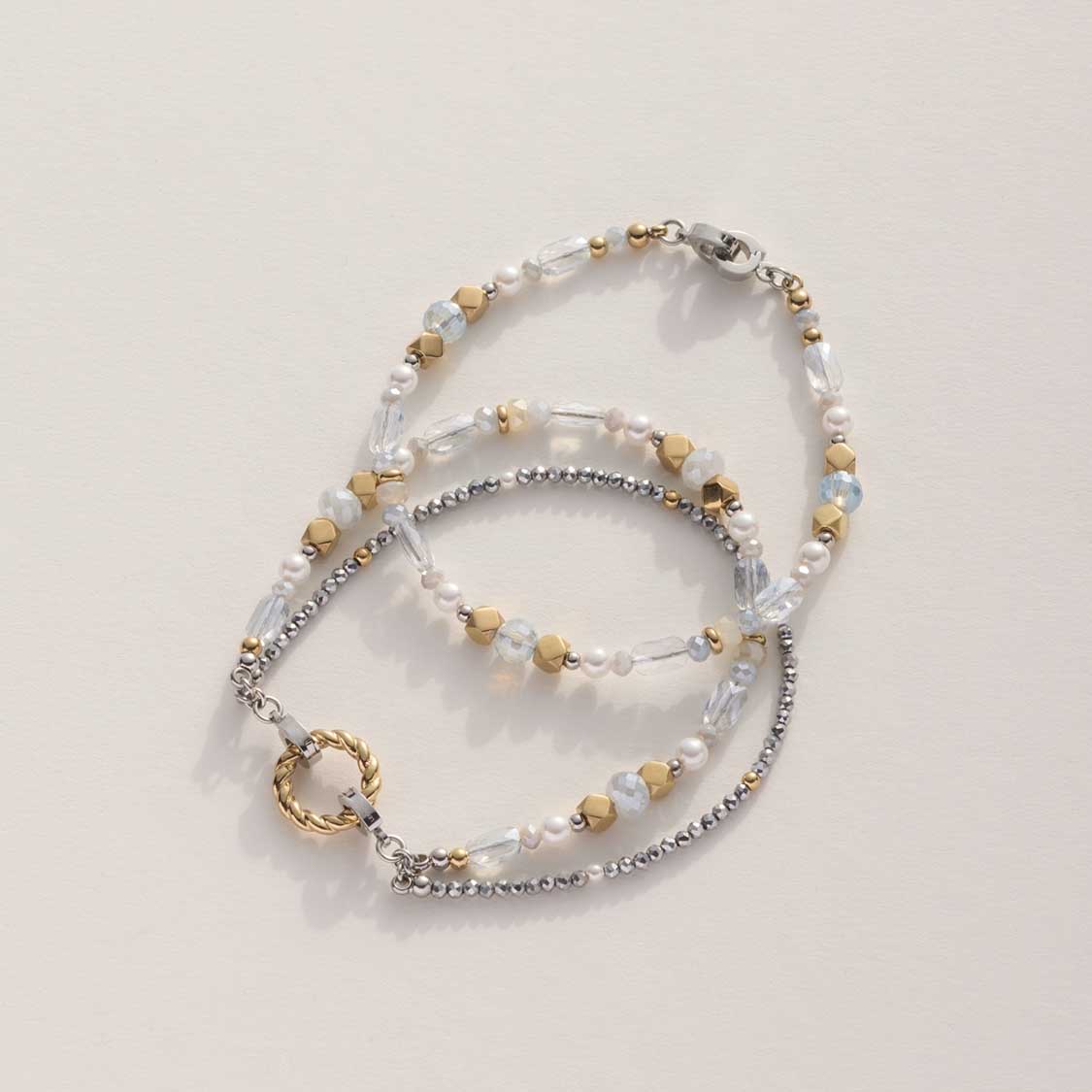Drei Armbänder der Serie ESTHER in Bicolor mit klaren und metallischen Perlen auf hellem Untergrund