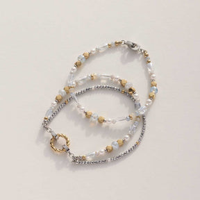 Drei Armbänder der Serie ESTHER in Bicolor mit klaren und metallischen Perlen auf hellem Untergrund