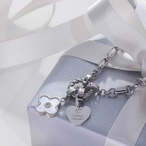 Halskette YVETTE mit Charms auf hellblauem Geschenkband und weißer Schleife
