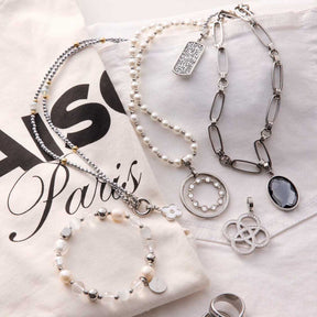 Mehrere Anhänger EDITH Clip & Mix auf Verpackung arrangiert, Perlenketten und Metallcharms in Silber