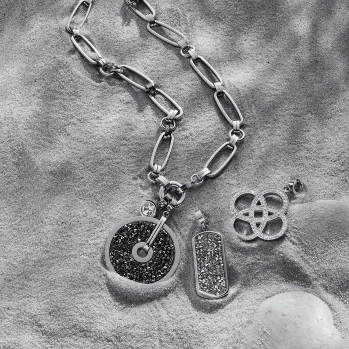 Anhänger EDITH Clip & Mix an Kette auf grauem Textilhintergrund mit Schmuckdetails