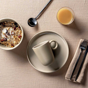 Keramiktasse ROMA auf gedecktem Frühstückstisch mit Müslischale und Saft