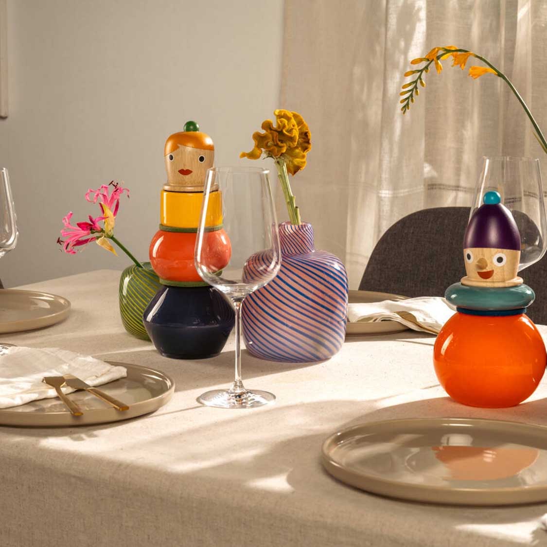 Objektvase BUONI AMICI auf gedecktem Tisch mit Blumen und Dekofiguren