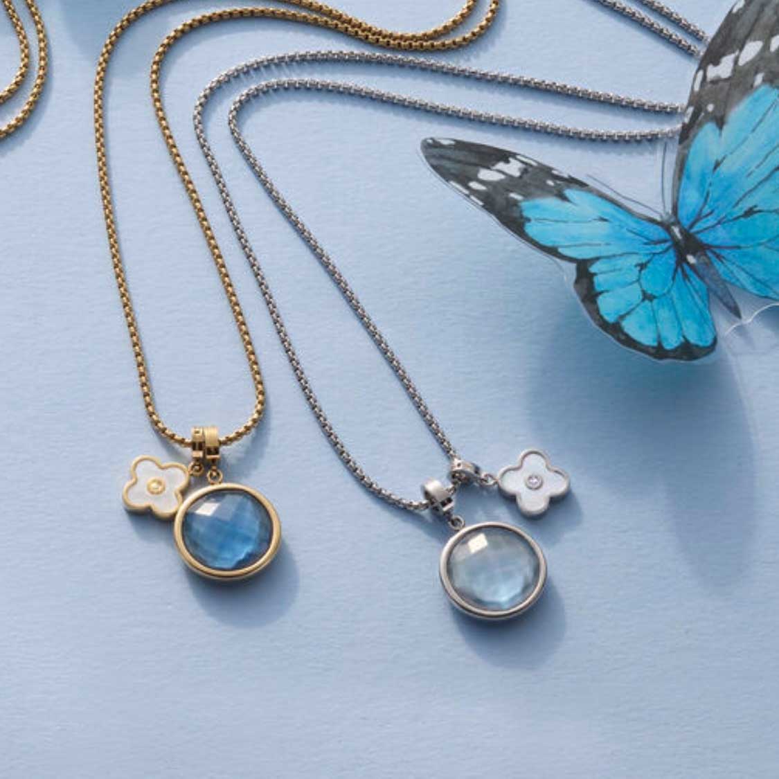 Zwei Anhänger MINKA mit Ketten, blauer Schmetterling, hellblauer Hintergrund