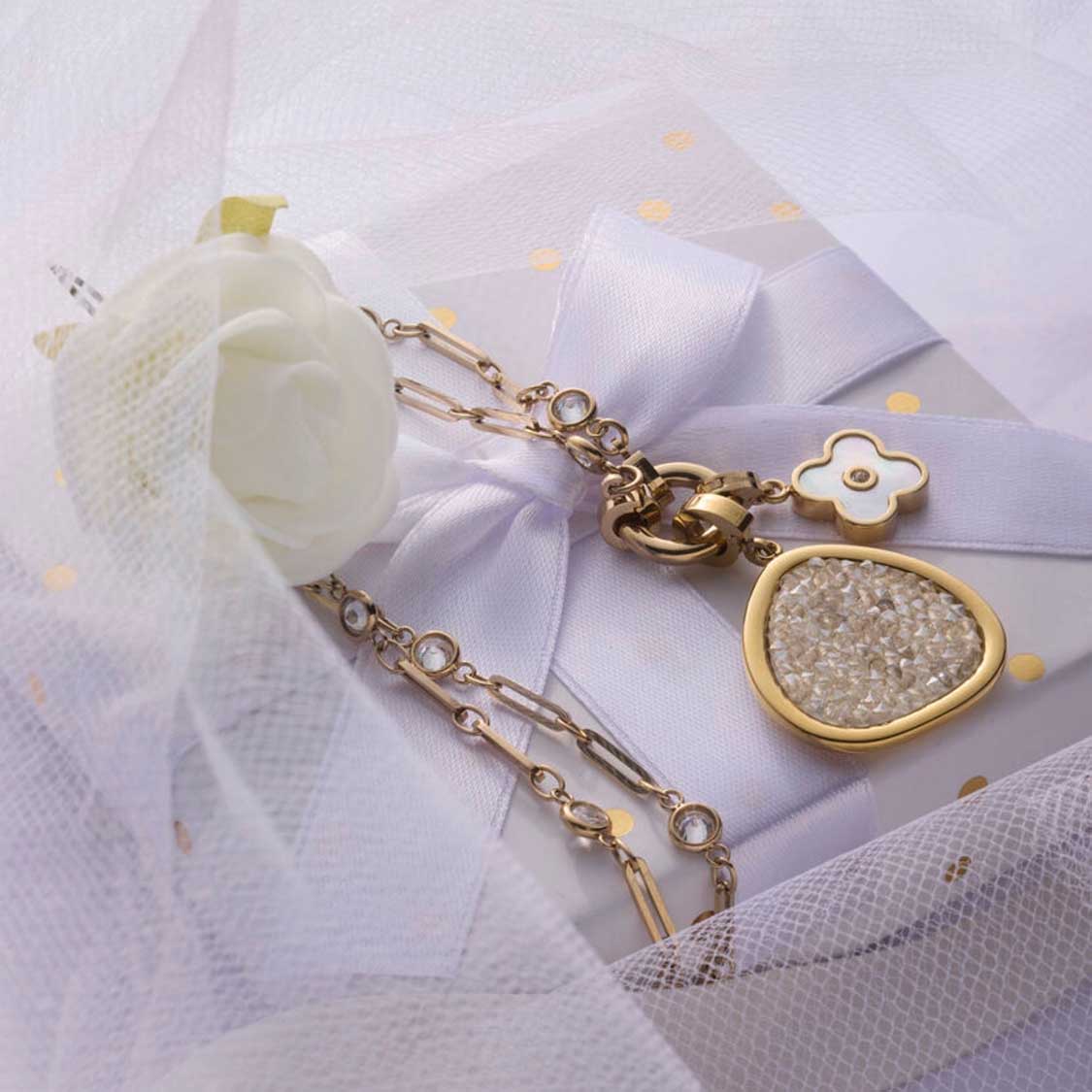 Anhänger BLUNA gold Clip & Mix mit Kettendetail auf weißem Tüll und Schleife