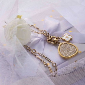 Anhänger BLUNA gold Clip & Mix mit Kettendetail auf weißem Tüll und Schleife