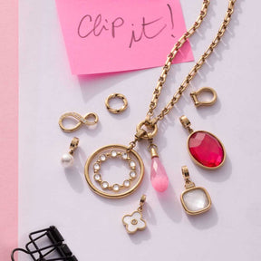 Anhänger FRISCO gold Clip & Mix mit verschiedenen Charms auf rosa Untergrund