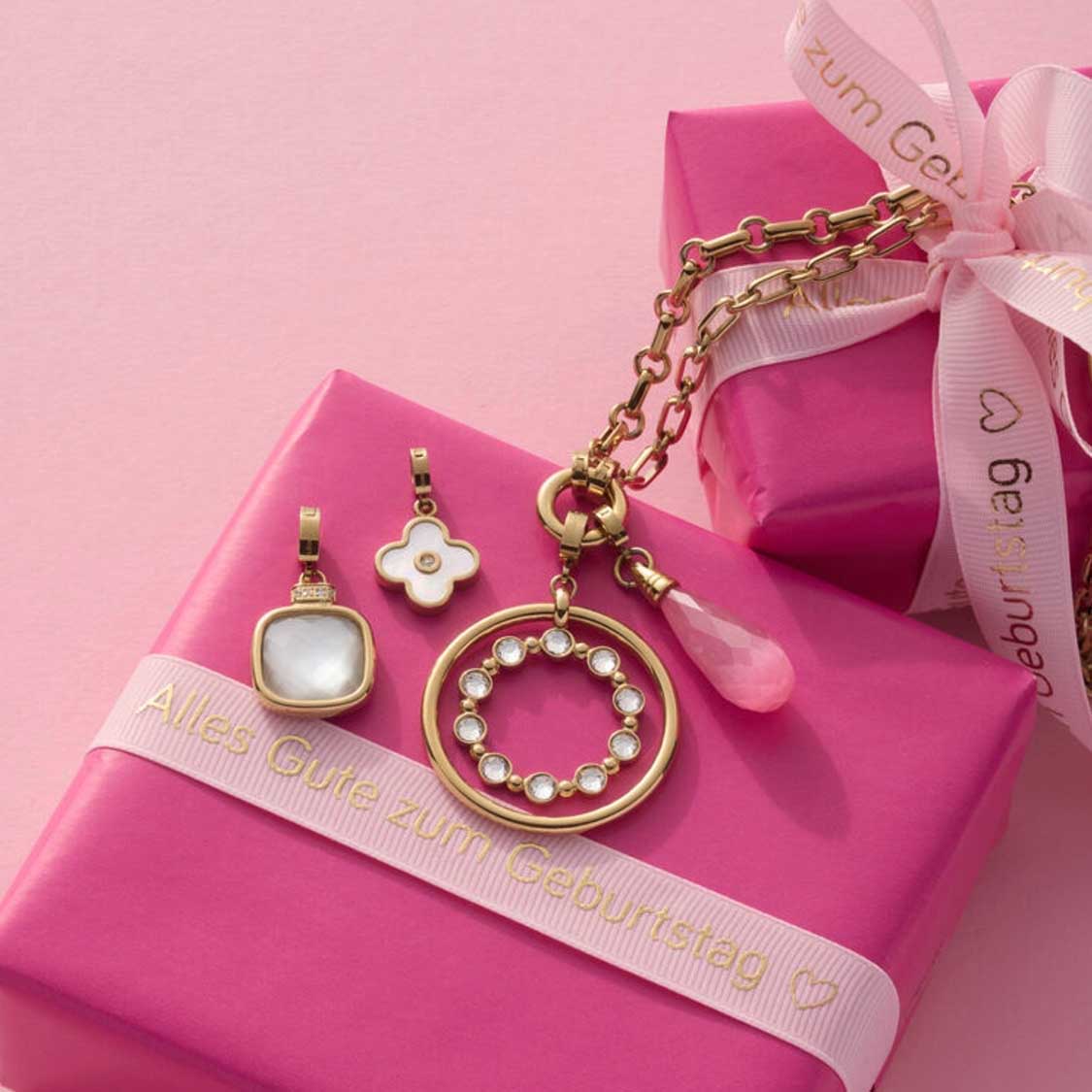 Anhänger FRISCO gold Clip & Mix mit vier verschiedenen Charms auf rosa Geschenkbox