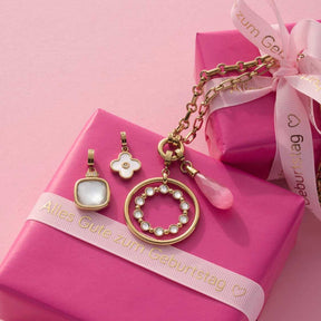 Anhänger FRISCO gold Clip & Mix mit vier verschiedenen Charms auf rosa Geschenkbox