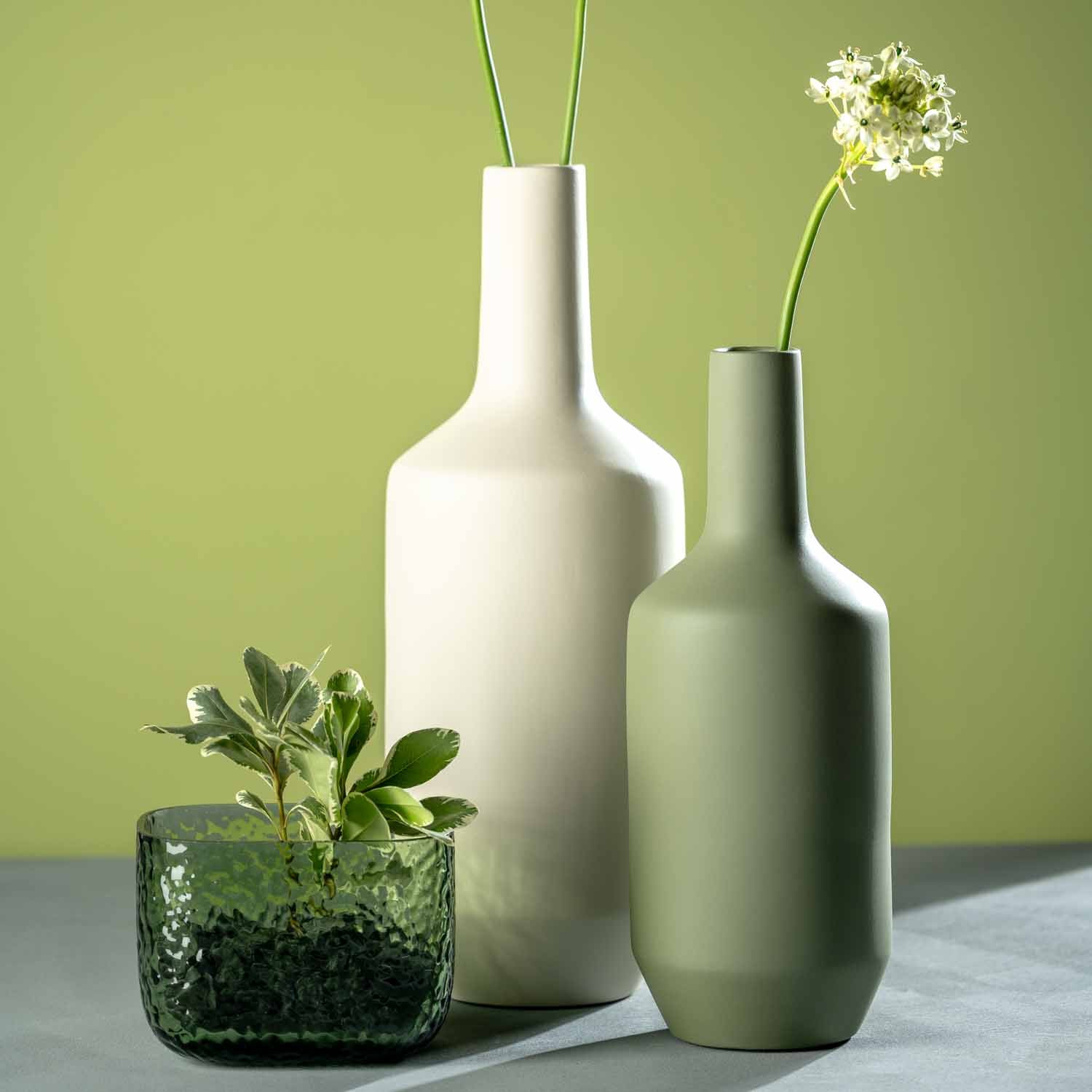 Keramikvase MILANO mit Blumen und Pflanzen auf grauem Untergrund vor grünem Hintergrund