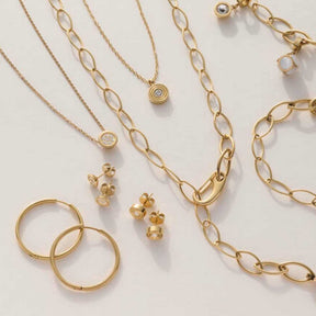 Ohrstecker ISABELLE gold mit Halsketten und Ringen in Goldtönen auf weißem Hintergrund