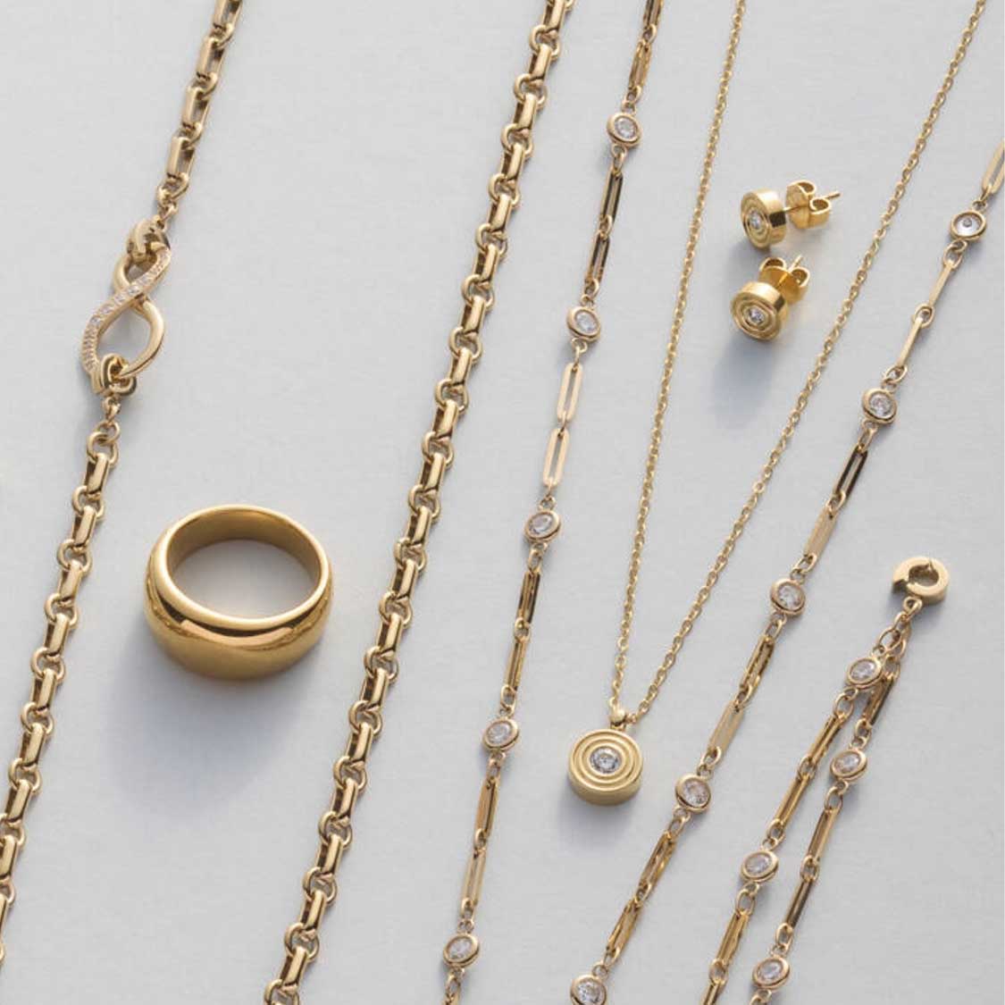Goldene Ketten und Ohrstecker ISABELLE, Ring und Schmuckelemente auf weißem Untergrund