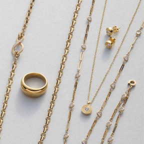 Goldene Ketten und Ohrstecker ISABELLE, Ring und Schmuckelemente auf weißem Untergrund