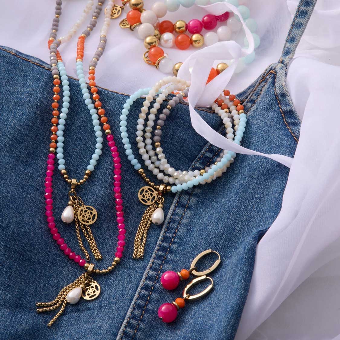 Halsketten und Ohrringe aus Glasperlen in Blau, Creme und Rosa auf Jeansstoff mit Zubehör