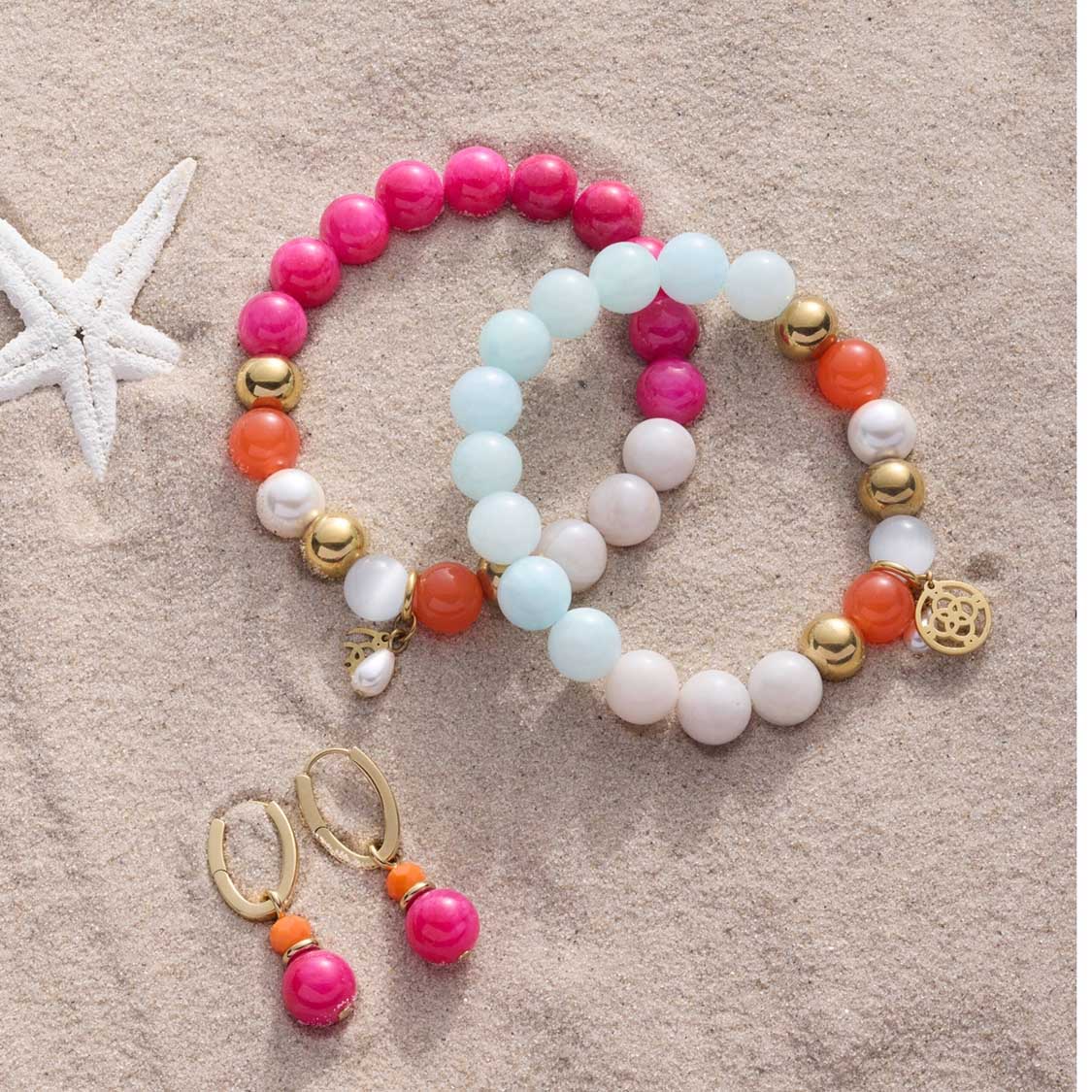 Armbänder SOLERA gold blau und Ohrringe auf Sand mit Muscheln