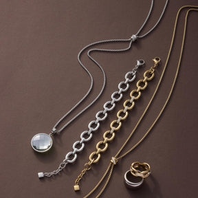 Halskette DARIA 90 cm mit Anhänger, Armbänder und Ring in Silber und Gold auf braunem Hintergrund