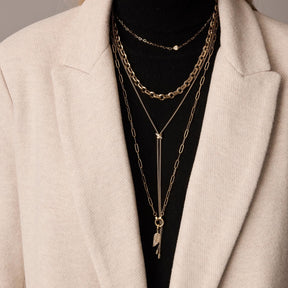 Halskette NALA 50 cm in Gold, mehrlagig um Hals getragen, über schwarzem Top und cremefarbener Jacke