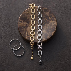 Armband BELLE gold und Silber mit Gliederkette auf marmoriertem Untergrund, daneben zwei silberne Ringe