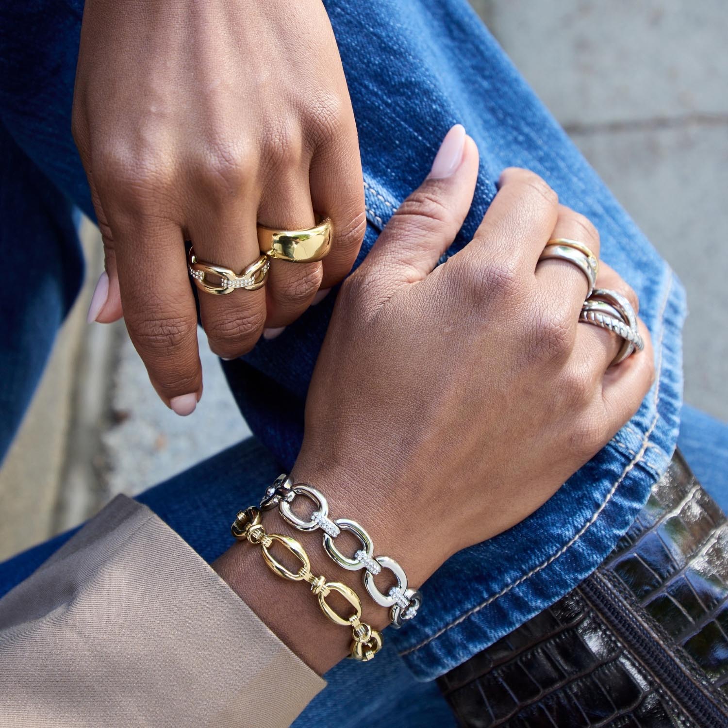 Frau trägt goldene Ringe und Armband an den Händen, Nahaufnahme