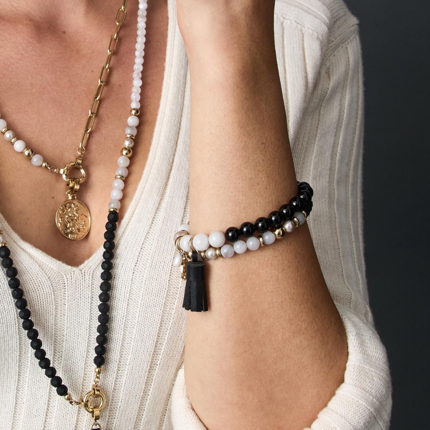 Armband EVE schwarz-weiß an Frauenhand, getragen mit Halsketten