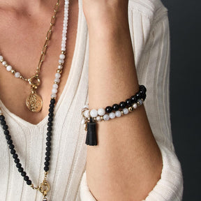 Armband EVE schwarz-weiß an Frauenhand, getragen mit Halsketten