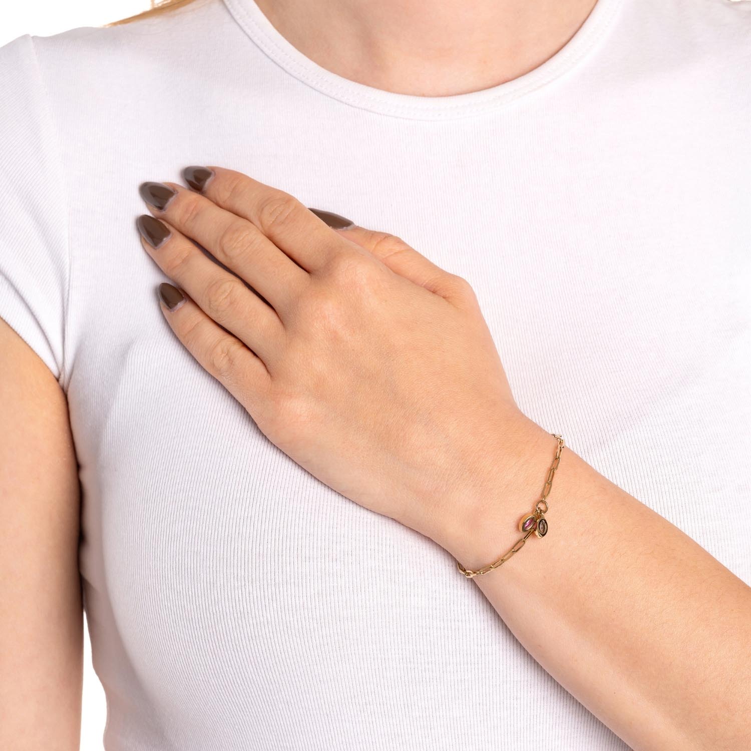 Armband MAY CIAO an Frauenhand, weiße Bluse, braune Nägel