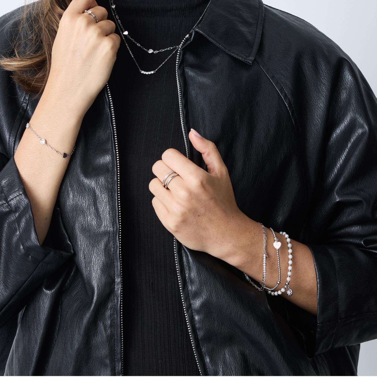 Frau trägt silbernes Armband TINI CIAO an Handgelenk, schwarze Lederjacke