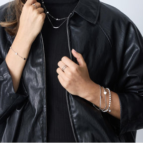 Frau trägt silbernes Armband TINI CIAO an Handgelenk, schwarze Lederjacke