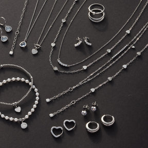 Schmuckkollektion mit Halsketten, Ringen, Ohrringen und Armband auf dunklem Hintergrund