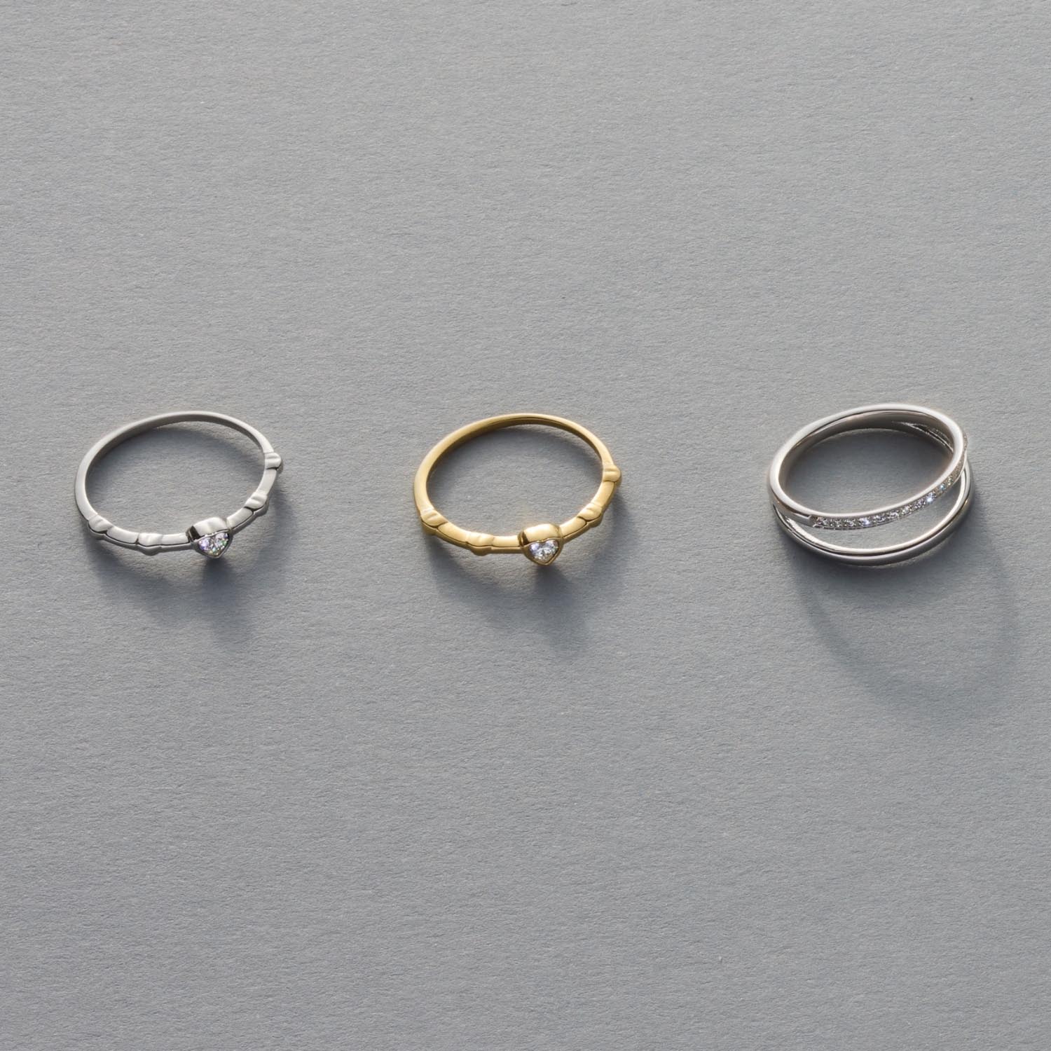 Drei Ringe CHRISTIE 17 CIAO in Silber und Gold auf grauem Hintergrund