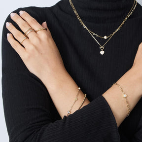 Frau traegt goldenes Armband CHRISTIE mit Perlen an der Hand