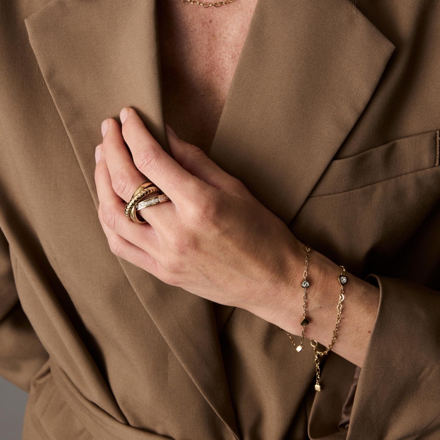 Frau traegt goldenes Armband CHRISTIE gold CIAO an Handgelenk, beige Oberteil