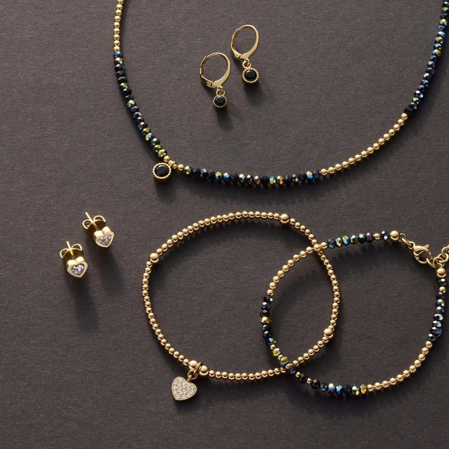 Ohrstecker CHRISTIE gold CIAO mit Zirkonia, Armband und Halskette auf grauem Untergrund