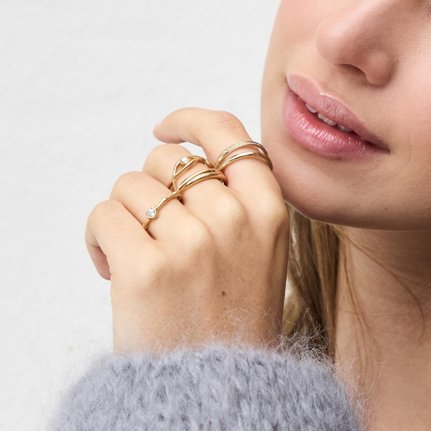 Frau trägt mehrere goldene Ringe CHRISTIE an der Hand