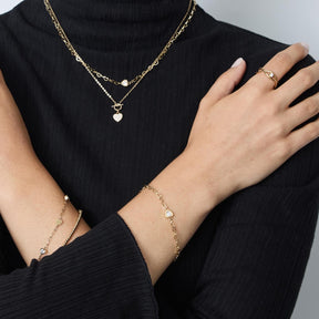 Armband JULY CIAO an der Hand einer Person, getragen mit Halskette und Ring